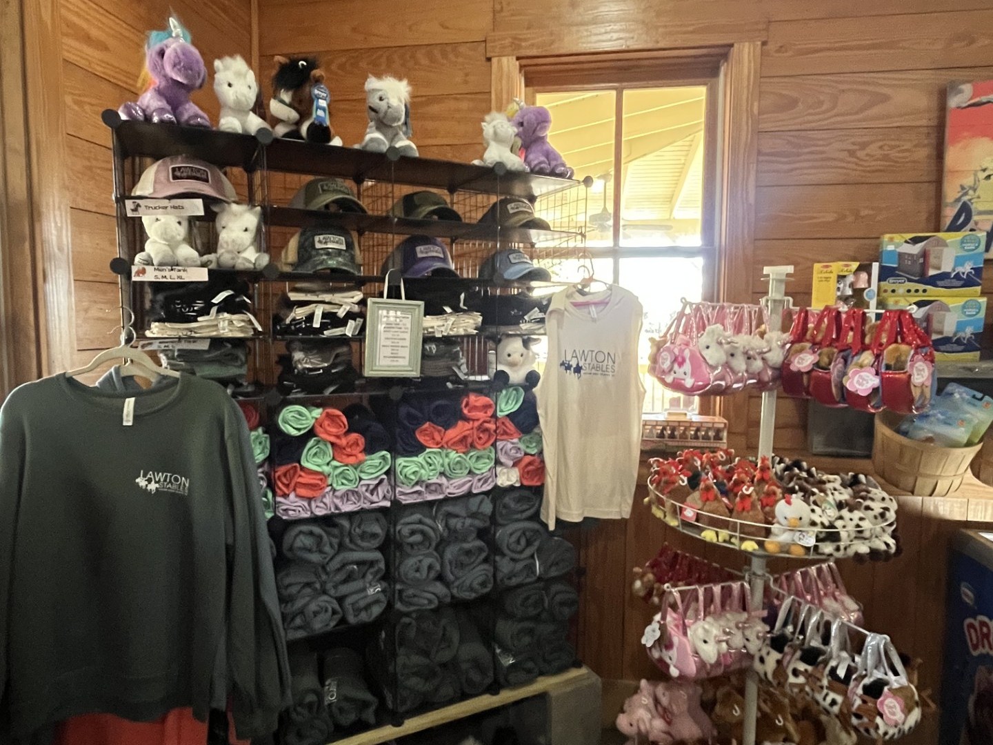 Gift shop with plush animals, hats, shirts, and small novelties on display.