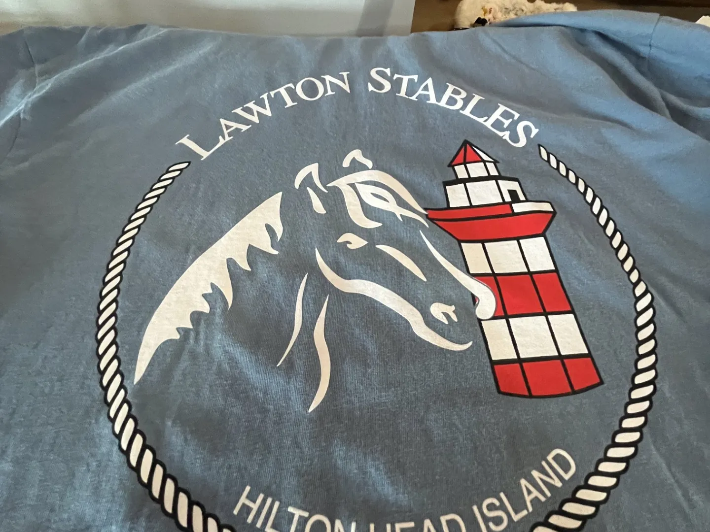 Blue shirt with horse outline and lighthouse logo for Lawton Stables, Hilton Head Island.