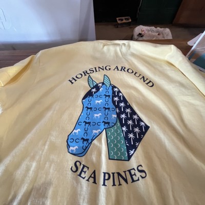 Yellow shirt with horse graphic and text 'Horsing Around Sea Pines'.