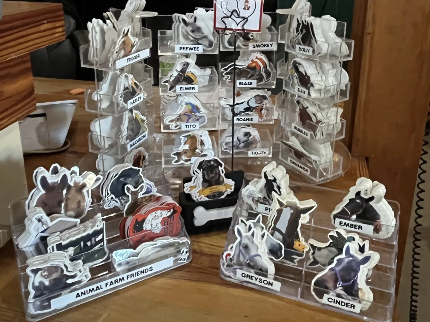 Display of animal stickers on a counter with names and prices.